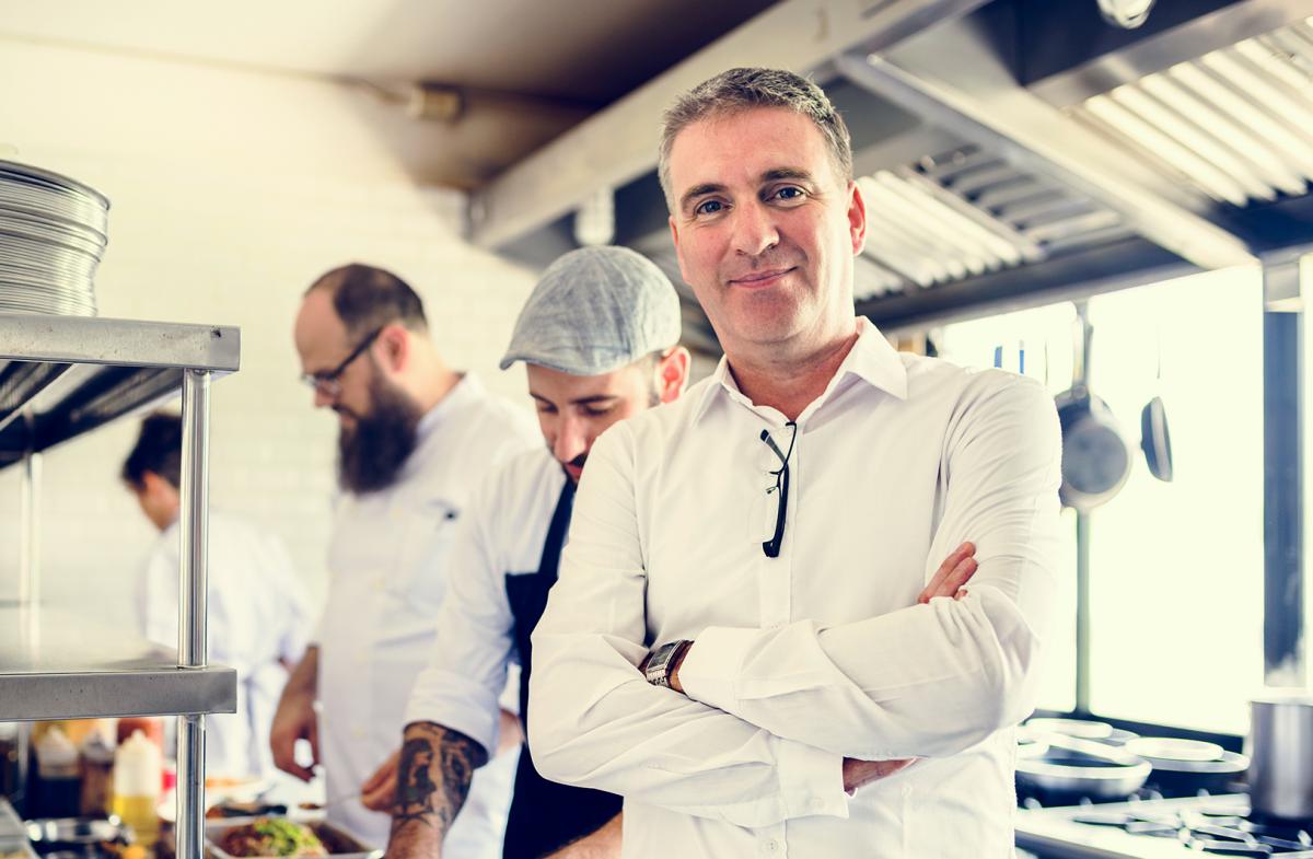 Restaurant Owner Standing in Commercial Kitchen